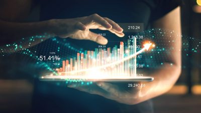 Person using technology with graphs and numbers in air